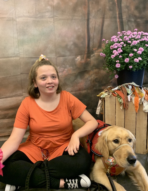 Girl sitting with service dog for photo